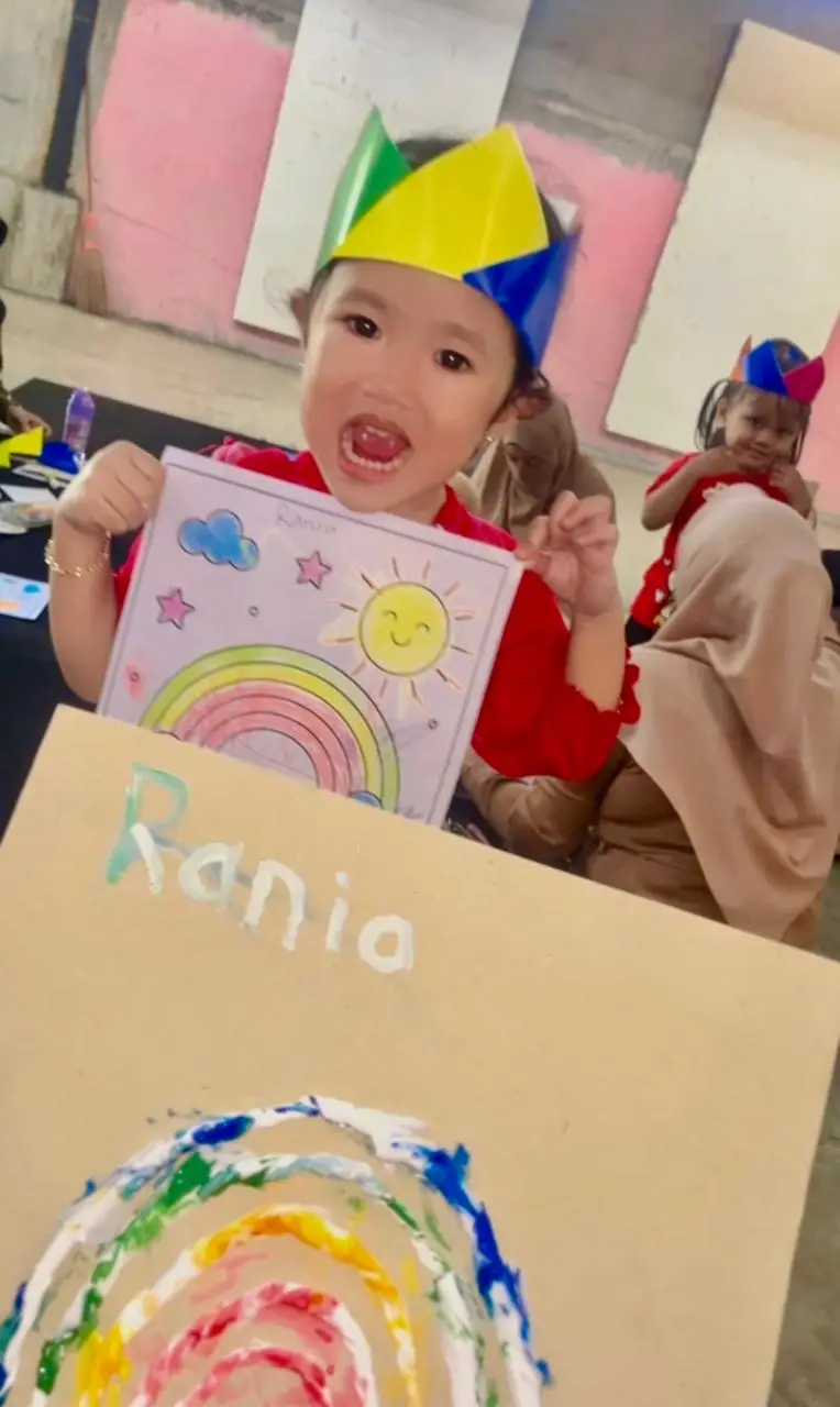 Anak memamerkan karya lukisnya